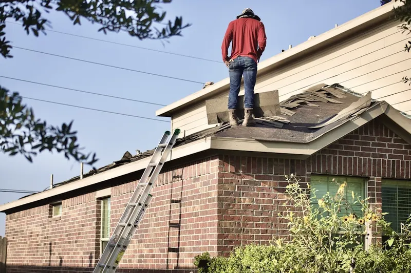 Professional roofer working on a residential roof in Frew Estates